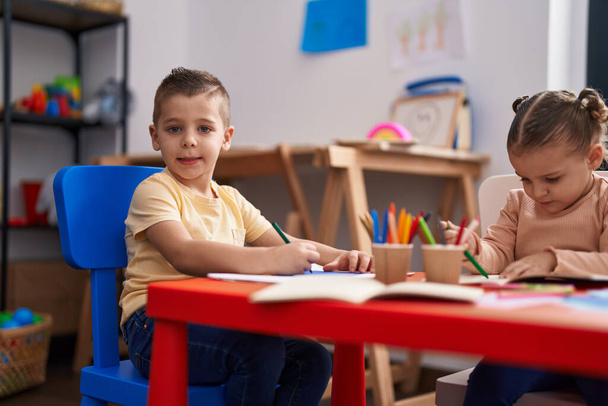 幼稚園の机の上に座っている2人の子供の未就学児 - 写真・画像