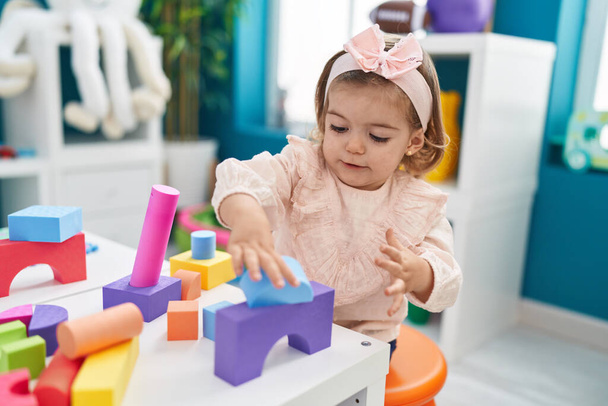 Adorable bambin blond jouant avec des blocs de construction debout à la maternelle - Photo, image