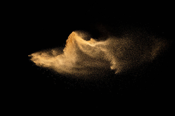 Dry river sand explosion.Brown color sand splash against black background. - Photo, Image