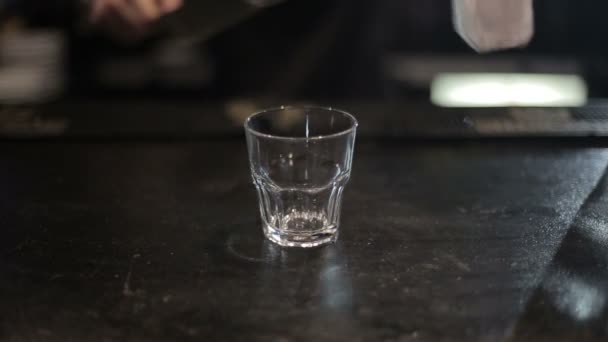 Bartender pouring a scotch whiskey with ice on the bar. Shot with slider - Záběry, video