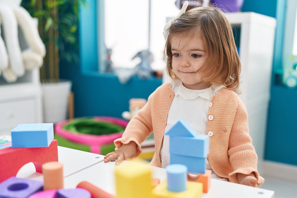 Adorable bambin blond jouant avec des blocs de construction debout à la maternelle - Photo, image