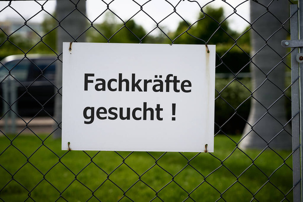  Notice on the fence of a company in Germany with the inscription Fachkrafte gesucht. Translation of the text: Professionals wanted                               - Photo, Image