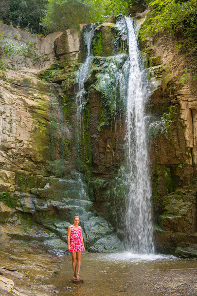bridge waterfall one girl in pink dress stands. High quality photo - Foto, imagen
