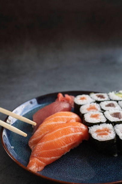 Delicious sushi rolls served on rustic table with chopsticks - Φωτογραφία, εικόνα