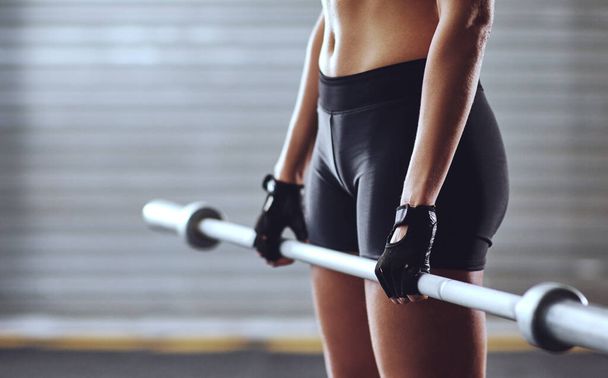 Du musst dir deine Muskeln verdienen. eine Frau, die im Fitnessstudio mit Gewichten trainiert - Foto, Bild