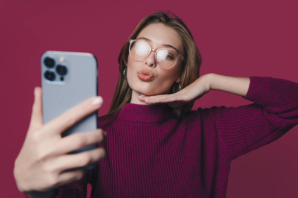 Portrait of attractive lovely brunette-haired woman taking selfie sending air kiss isolated over crimson color background - Fotografie, Obrázek