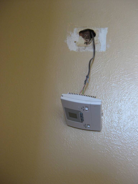 Thermostat Hanging from its Wires in Hallway . High quality photo - Foto, afbeelding