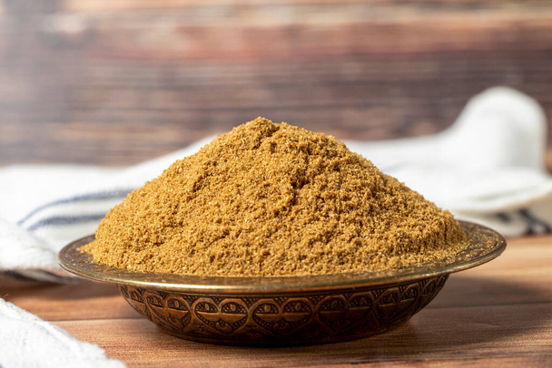 Powdered cumin spice. Cumin spice in bowl on wooden background. Dry spice concept. close up - Foto, Bild