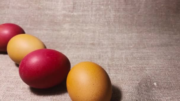 Brown, red and yellow chicken eggs. Painted easter eggs on a brown linen bedspread. Easter eggs. - Video, Çekim