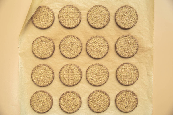 Freshly baked homemade sesame seed cookies on wooden board, rustic table. Healthy, tasty snack, honey seed bar, round form biscuits. Organic dessert, top view in row vegan - Zdjęcie, obraz