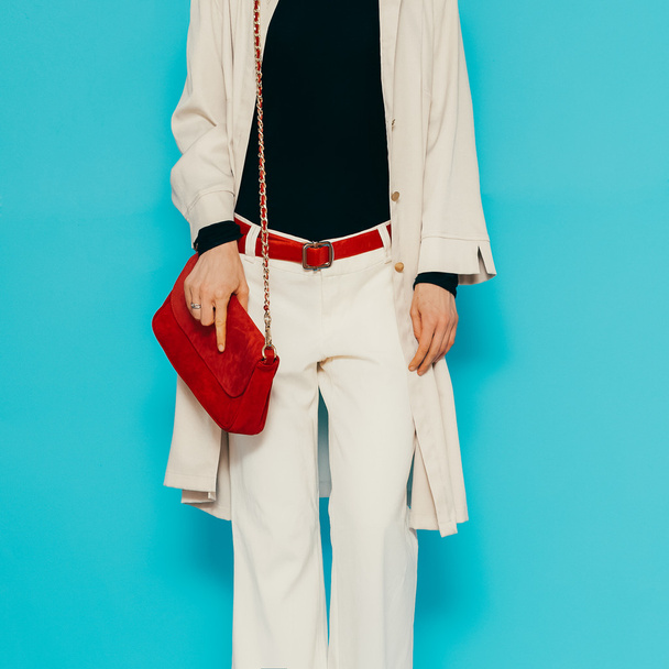 Модная дама в стильной белой одежде. Белые брюки и плащ с красными аксессуарами
 - Фото, изображение