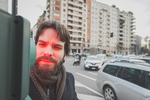 Young handsome bearded man posing in the city streets - Foto, afbeelding