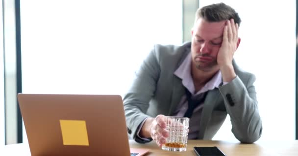 Humalainen liikemies, joka pitelee lasia alkoholilla työpaikalla. Emotion stressi masennus ja alkoholismi työssä - Materiaali, video
