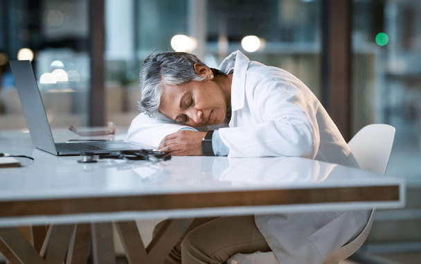 Жінка-лікар спить за столом в овертаймі, лікарні і вигоряння. Стрес, ніч і працівник охорони здоров'я за столом з втомою, втомленою роботою і проблемами психічного здоров'я від перевтоми
. - Фото, зображення