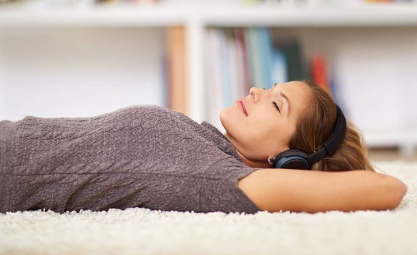 So abgekühlt jetzt... eine junge Frau hört Musik, während sie sich zu Hause entspannt - Foto, Bild