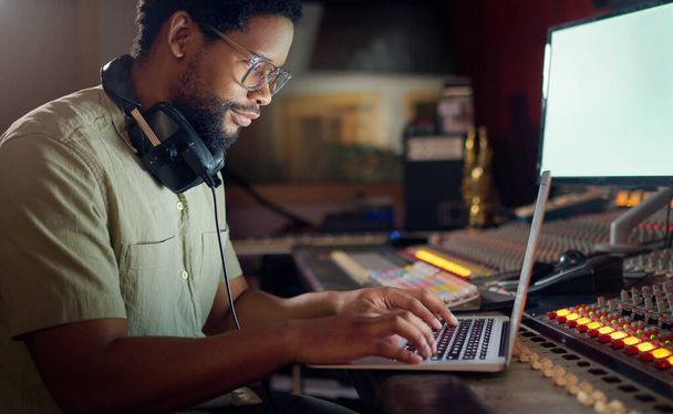 Black man, thinking and laptop for music recording, sound engineering or song composition in studio. Producer, DJ and musician on technology with ideas for live streaming radio, audio or media album. - Valokuva, kuva