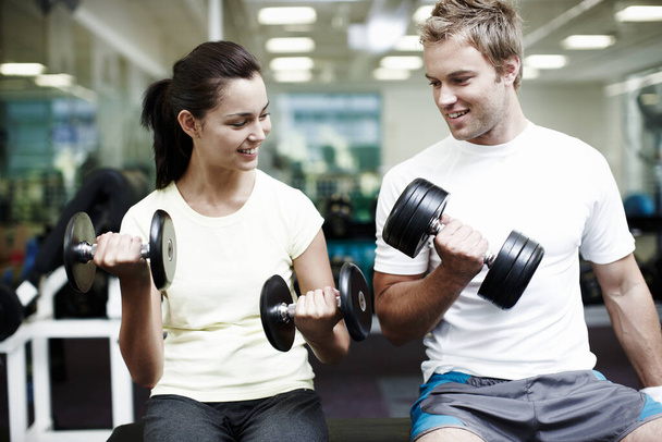 How you doing with that. two people working out using dumbbells in the gym - Photo, image