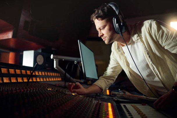 Dj, thinking or recording headphones for music, sound mixing or computer song composition in studio. Musician, man or producer on technology with ideas for live streaming radio, audio or media album. - 写真・画像