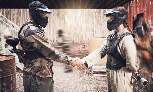 Handshake, paintball team and congratulations or support, sports game on battlefield and partnership with agreement. Mask for safety, speed and gun, people together on shooting range with trust. - 写真・画像