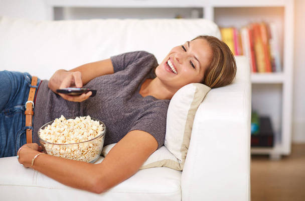 El descanso, la relajación y una comedia romántica. una joven mujer viendo la televisión en casa - Foto, imagen