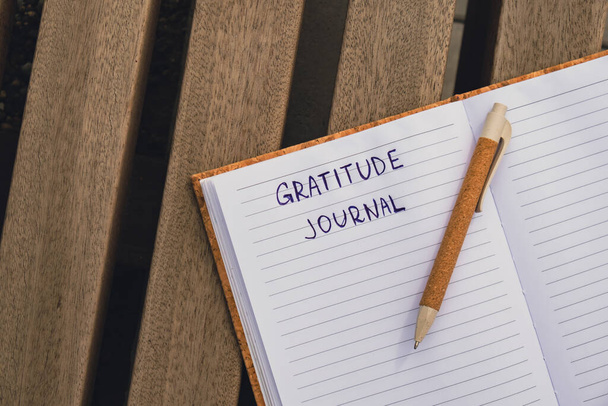 Escribiendo Gratitude Journal en un banco de madera. Hoy estoy agradecido. Diario del descubrimiento del uno mismo, escritura creativa del autoreflexión, concepto del desarrollo personal del uno mismo. Autocuidado bienestar espiritual - Foto, Imagen