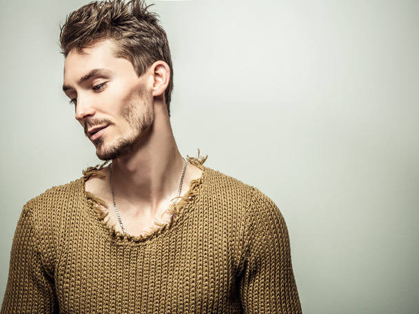 Studio portrait of young handsome man in knitted sweater. Close-up photo. - Foto, afbeelding