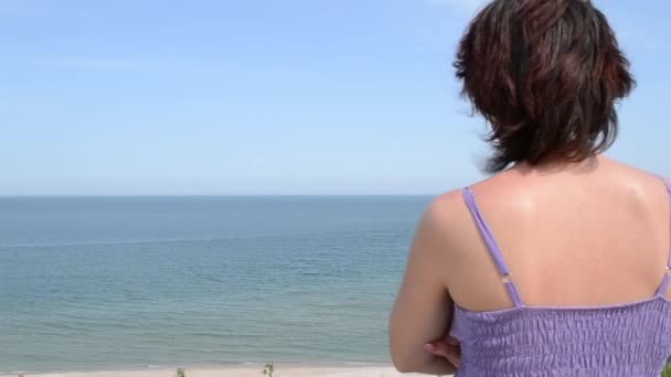 Mujer está mirando hacia el horizonte del mar
 - Imágenes, Vídeo