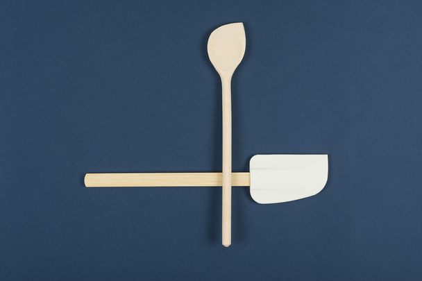 Cuillère et spatule en bois sur fond bleu
 - Photo, image