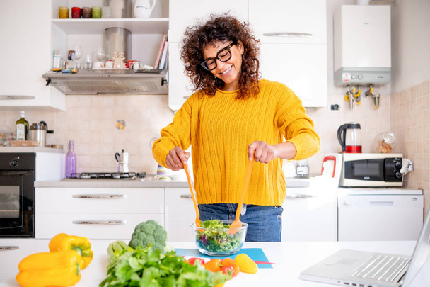 Black woman preparing salad. Healthy eating concept - Фото, изображение
