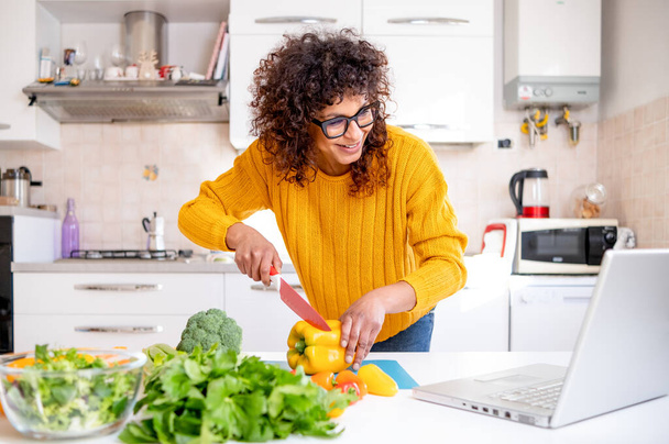 Happy black woman learning to cook at home with online courses - Foto, Bild