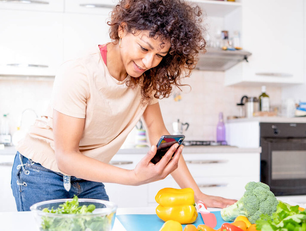 Cheerful black woman purchasing online food and searching meal recipes - Foto, afbeelding