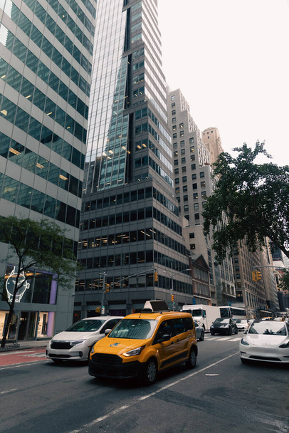 NEW YORK, USA - OCTOBER 13, 2022: yellow taxi car in traffic on road in midtown of city - Foto, afbeelding