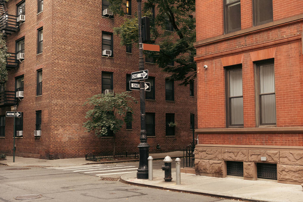 Pointers between brick buildings on street in New York City - 写真・画像