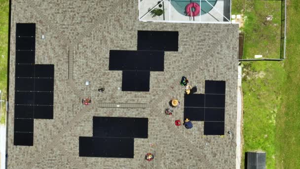 Aerial view of workers working on residential private home installing solar panels on roof with asphalt shingles. Development of photovoltaic energy concept. - Video