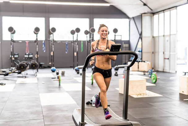 young woman training gym running treadmill smiling happy  - Photo, image