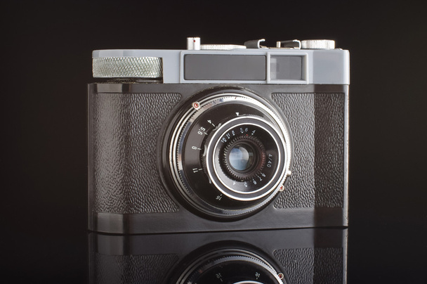 Vintage analogue photo camera isolated with reflection on the black background - Photo, Image