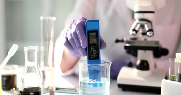 Wetenschapper werkt aan chemische oplossing met behulp van pH-meter in laboratorium. Studie van de waterkwaliteit van toxinen - Video