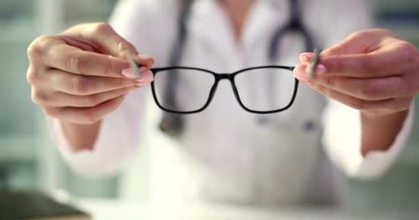 Optometrist gives glasses for good vision closeup. Optometry prescription for glasses and eye health - Filmati, video
