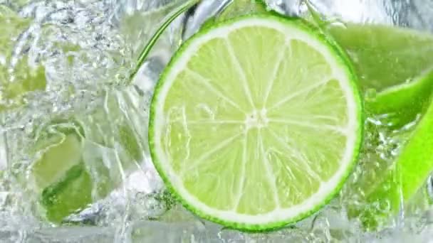 Super Slow Motion Shot of Pouring Lemonade into Glass With Lime Slices and Ice Cubes at 1000 fps. Filmed with High Speed Cinema Camera at 4K. - Felvétel, videó