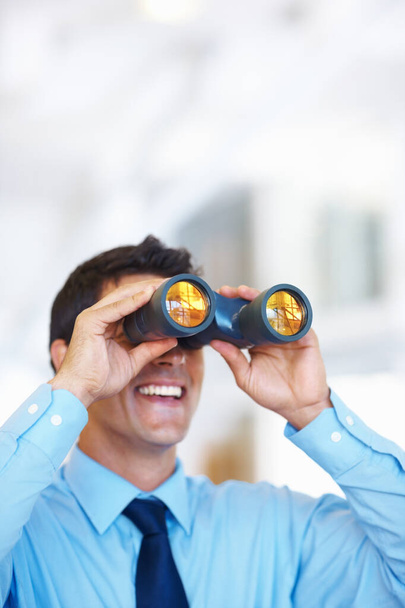 Business tactician. Portrait of attractive young business man using binoculars - Fotografie, Obrázek