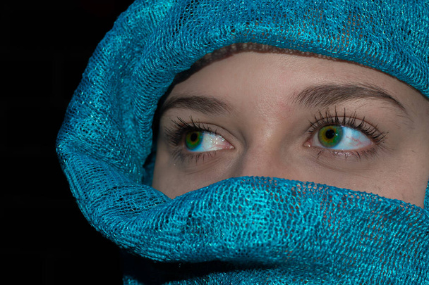 green-eyed girl with her face wrapped in a green turban. close up of a girl with beautiful green eyes wearing a green hijab - Foto, immagini