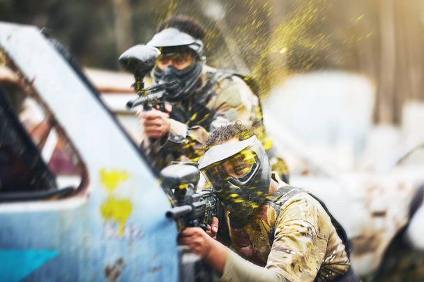 Paintball, shooting and people in action competition, game or match as a competitive team on a battleground. Aim, gun and player or teamwork of group in extreme sports with camouflage and safety mask. - Foto, Imagem