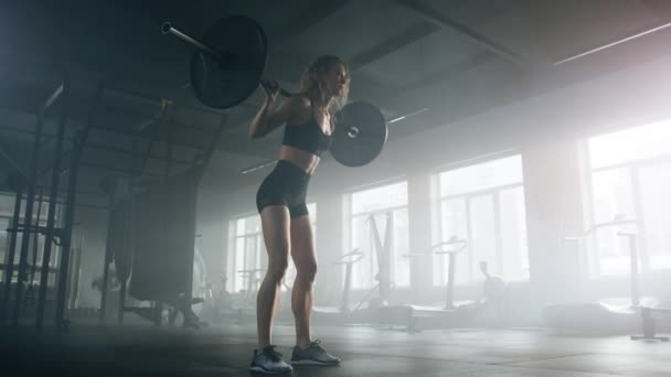 Aktif, formda bayan gücünü yoğun egzersizle test ediyor. Karanlık, modern spor salonundaki halter eğitimi sırasında kadın kaldırıcının yakın çekim görüntüsü. Yüksek kalite 4k görüntü - Video, Çekim
