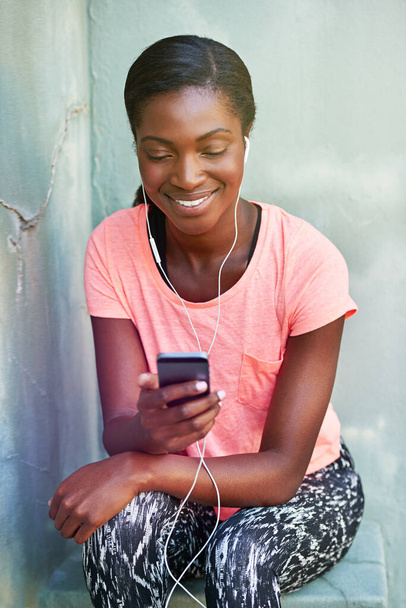Music motivates her. an attractive young woman listening to music while working out - Fotó, kép