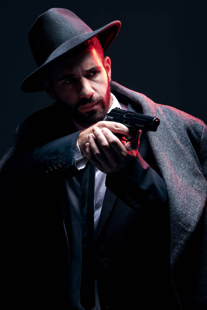 Bodyguard, suit or shooting gun on studio background in dark secret spy, isolated mafia leadership or crime lord security. Model, man and gangster aiming weapon in formal or fashion clothes aesthetic. - Foto, afbeelding