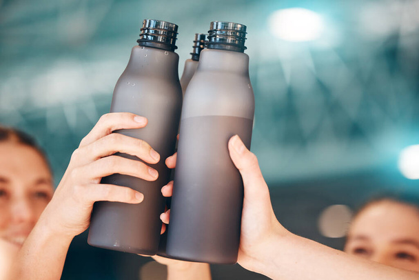 Hands, fitness and cheers with bottle water for team training, exercise or workout achievement in sports. Hand of sport group celebration touching bottles for drinking, hydration or winning in unity. - Foto, Imagem