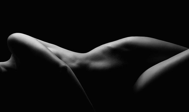 Mujer desnuda tumbada en la oscuridad. Hermosa chica desnuda sexy del cuerpo. Silueta en blanco y negro - Foto, imagen