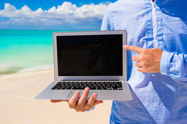 Νεαρός άνδρας με φορητό υπολογιστή κατά τη διάρκεια του διακοπές στην παραλία - Φωτογραφία, εικόνα