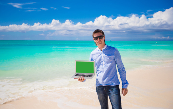 Joven con portátil durante las vacaciones en la playa
 - Foto, Imagen