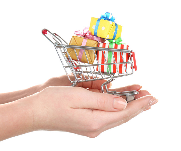 Small shopping cart in female hands isolated on white - Fotó, kép